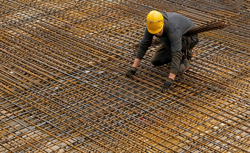 Construction worker with safety gear being monitored by drone systems